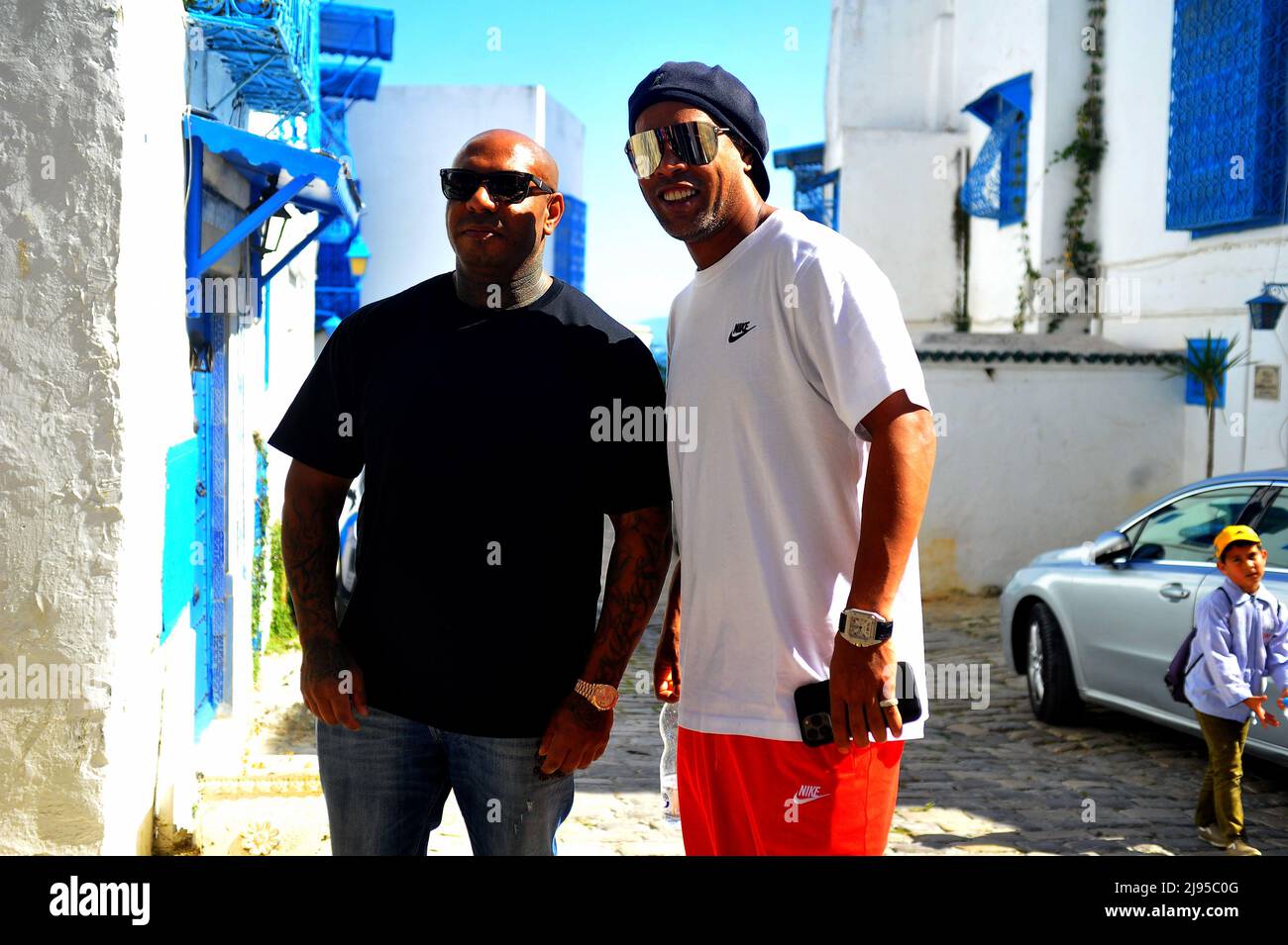 Sidi Bou dit, Tunis, Tunisie. 20th mai 2022. Ronaldinho à Sidi Bou Said (ville touristique au nord de Tunis) ancien joueur de Paris Saint Germain, FC Barcelone et AC Milan. Vainqueur de la coupe du monde avec le Brésil en 2002 et ballon d'Or 2006 en Tunisie à partir de mai 19. C'est l'artiste K2Rym(L) qui l'a annoncé dans une vidéo publiée sur sa page Facebook officielle.l'objectif de la visite de Ronaldinho est de ''promouvoir le tourisme et le patrimoine tunisien'' et de montrer au monde que la Tunisie est toujours une destination sûre.photo de Yassine Mahjoub. (Credit image: © Chokri Mahjoub/ZUMA Press Wire) Banque D'Images