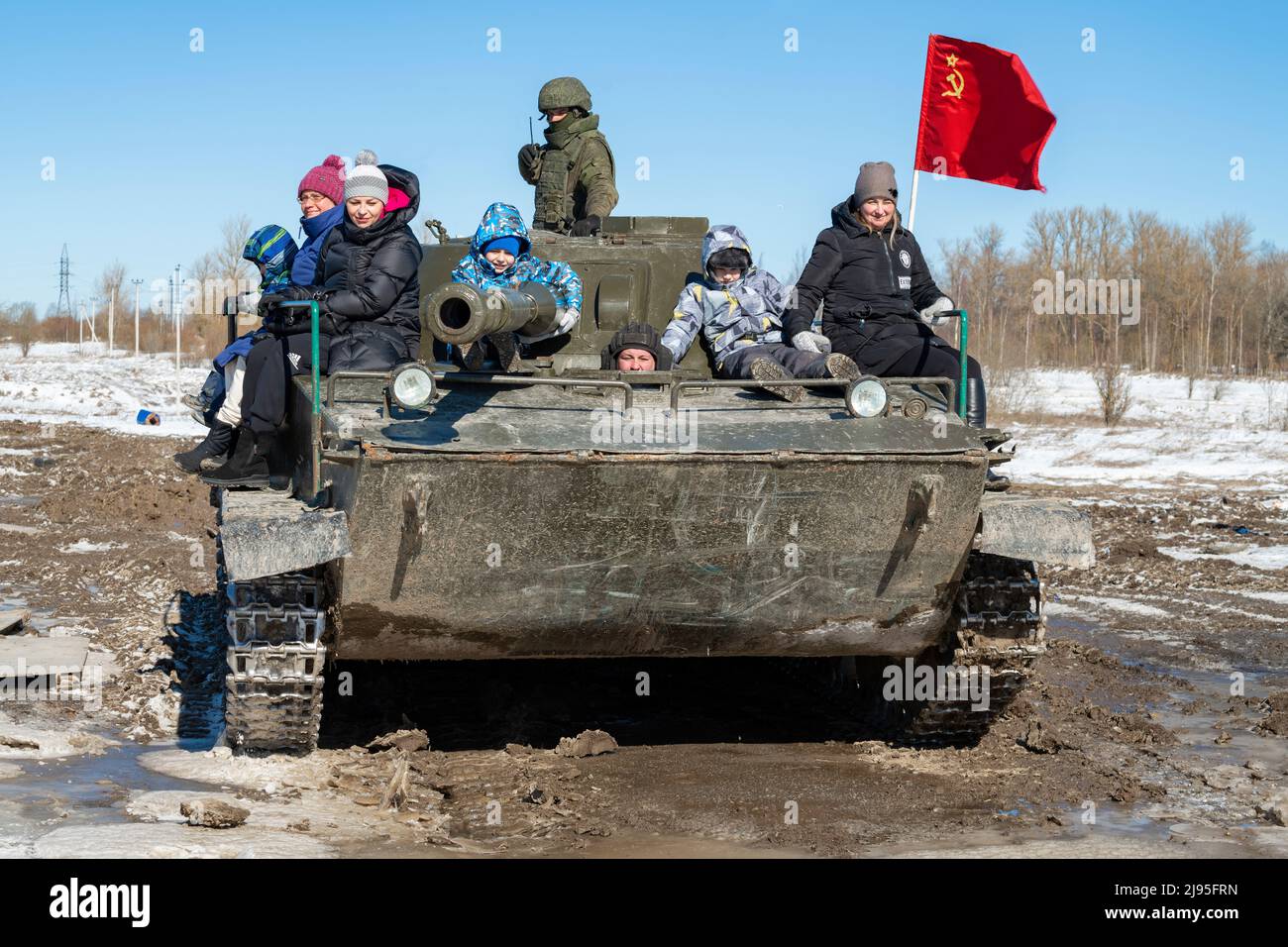 KRASNOE SELO, RUSSIE - 27 MARS 2022 : des visiteurs avec des enfants se rendent dans le réservoir amphibie soviétique de PT-76 le jour de mars ensoleillé. Militaire patriotique par Banque D'Images