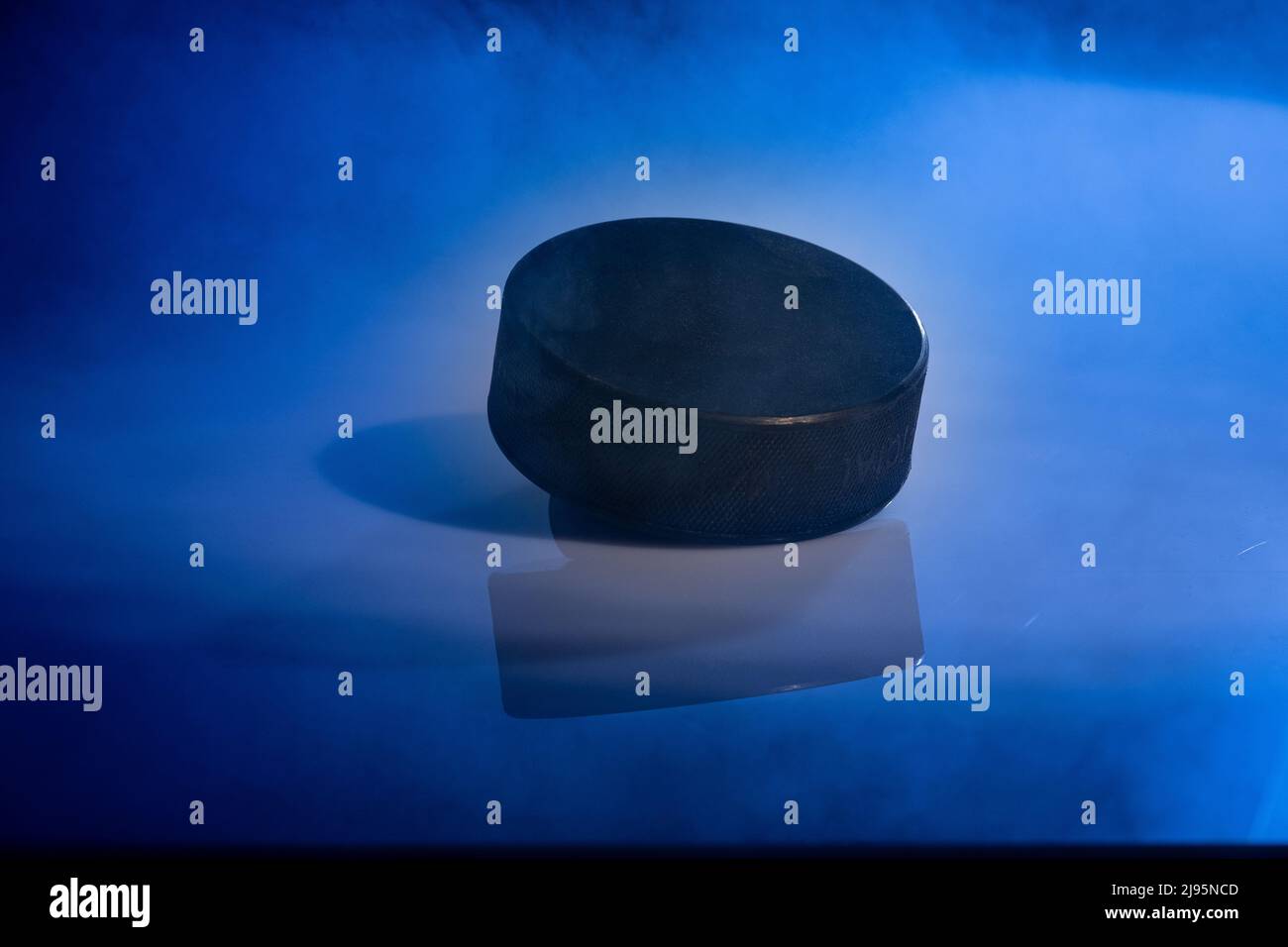 Helsinki / Finlande - 20 MAI 2022 : gros plan d'un disque de hockey sur glace caoutchouteux sur fond bleu fumé. Banque D'Images