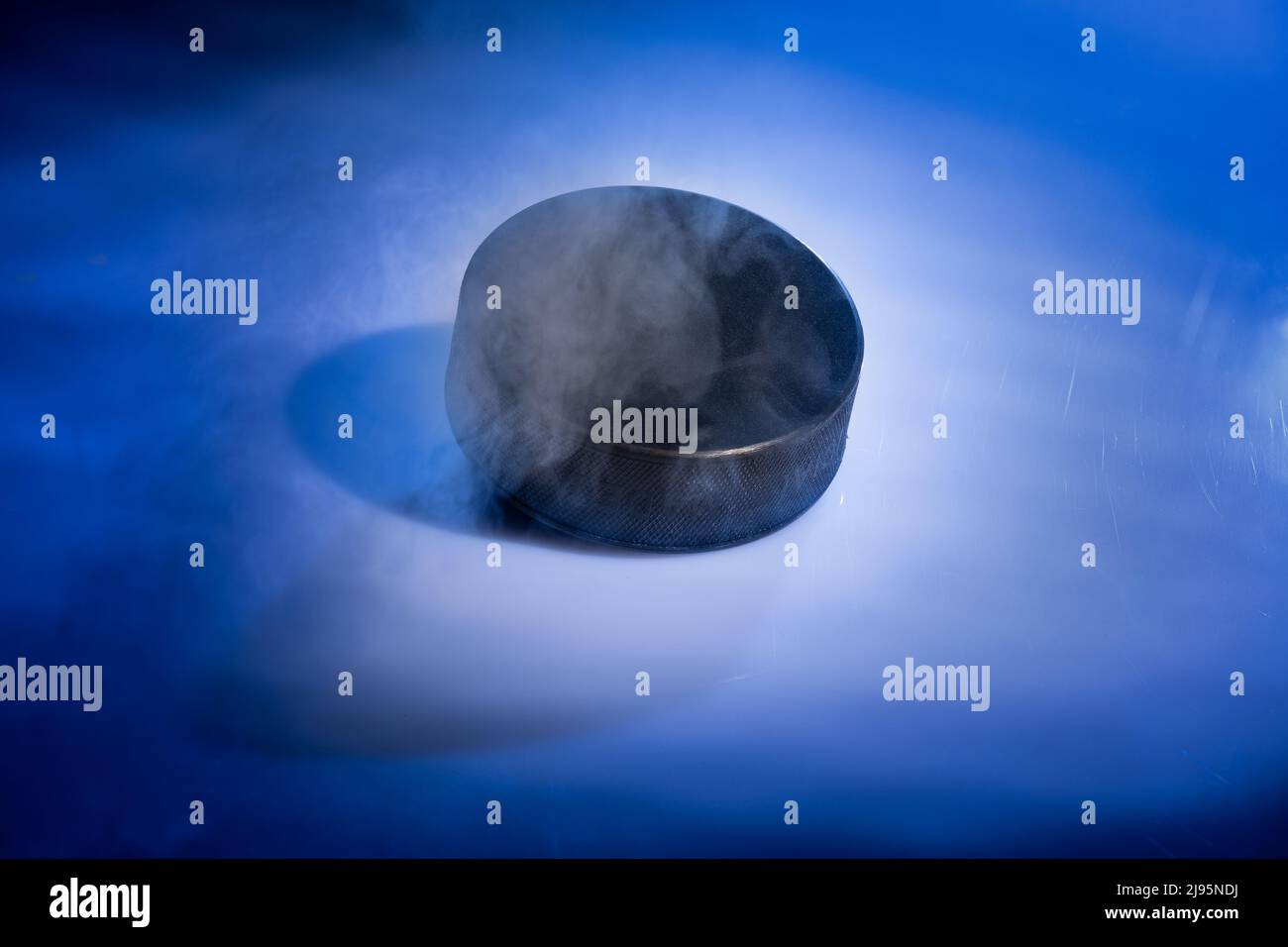 Helsinki / Finlande - 20 MAI 2022 : gros plan d'un disque de hockey sur glace caoutchouteux sur fond bleu fumé. Banque D'Images