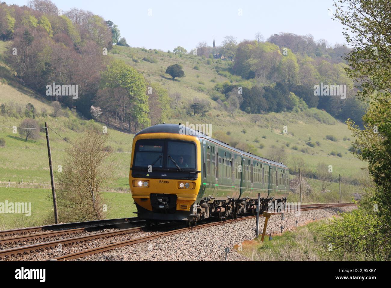 Un train traversant de beaux paysages dans les collines de Surrey, le jour du soleil, avec une église sur la colline en arrière-plan Banque D'Images