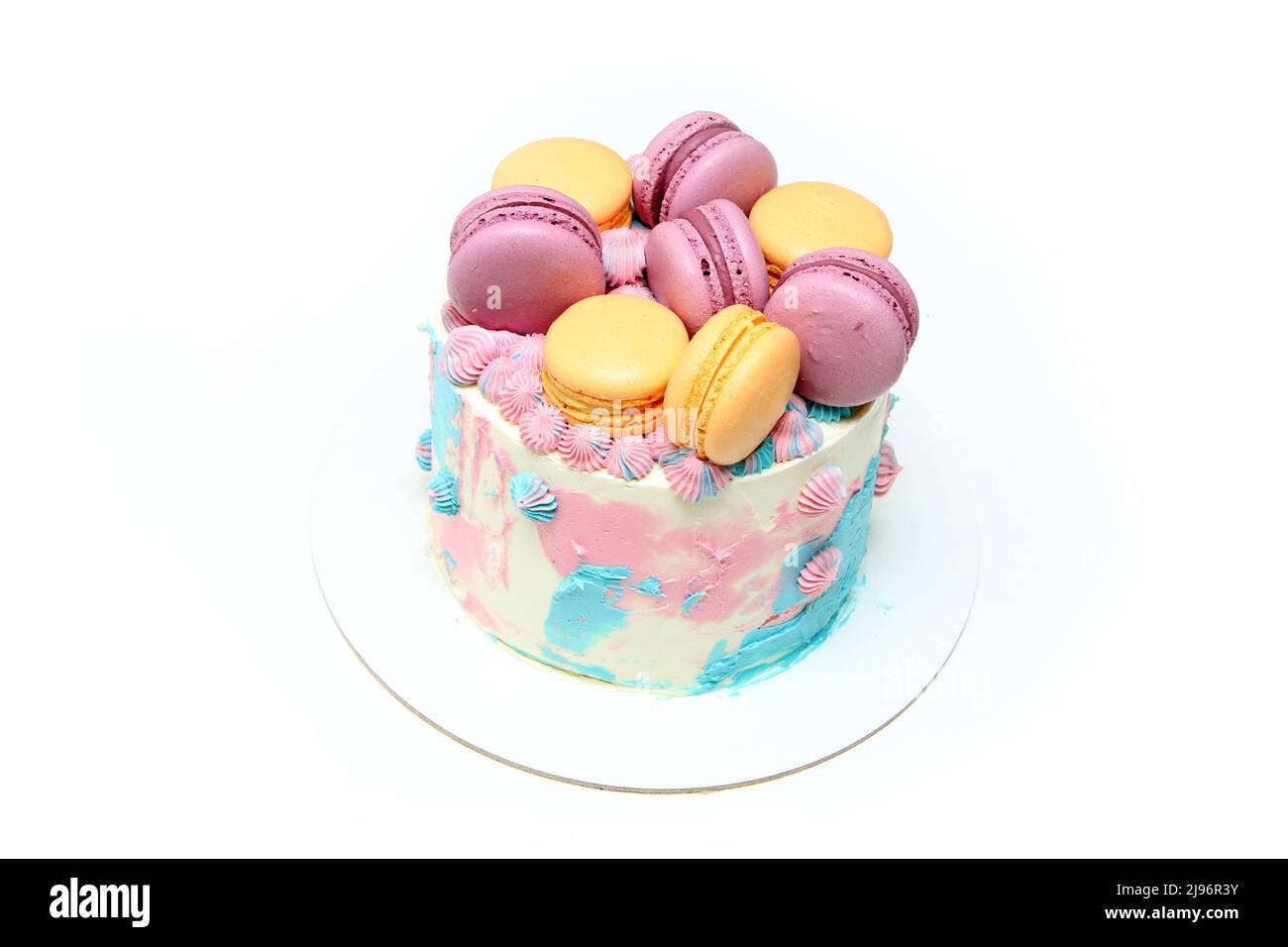 Le petit gâteau coloré et délicieux avec plusieurs macrons dessus. Isolé sur un fond blanc. Banque D'Images
