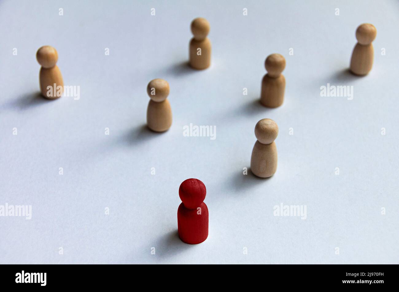 Poupée en bois rouge dirigeant le reste d'autres poupées en bois sur fond blanc.leadership ou concept d'embauche Banque D'Images