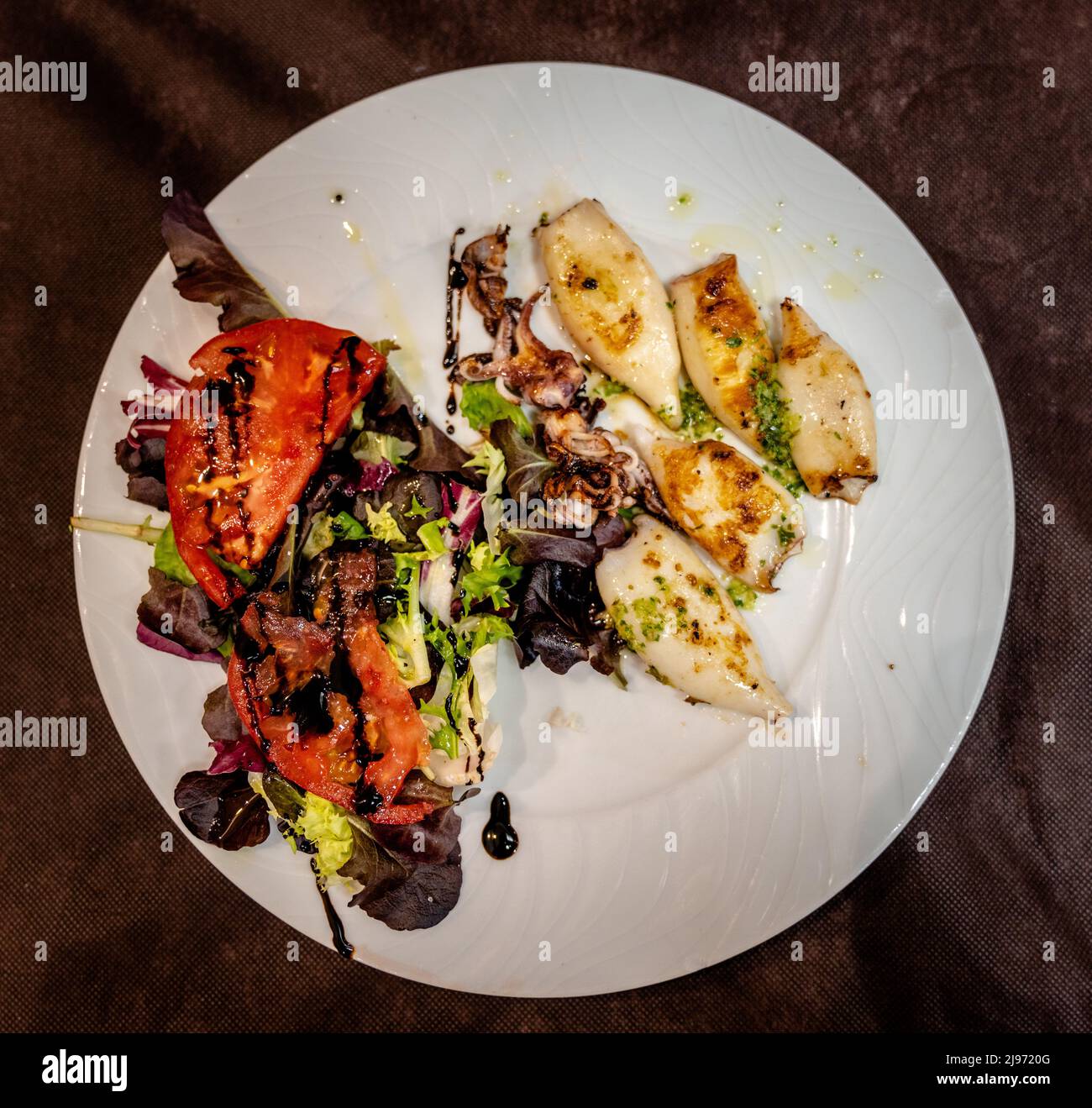 Une vue de haut en bas de bébé grillé calmar style Gallego avec une salade mixte Banque D'Images