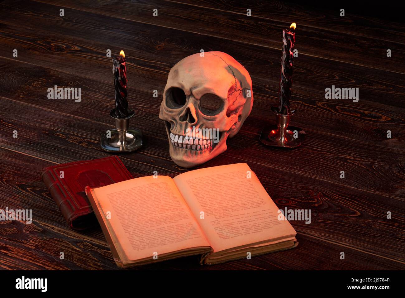 Encore la composition de la vie de substance pour rituel satanique . Crâne humain avec bible satanique et bougies allumées. Banque D'Images