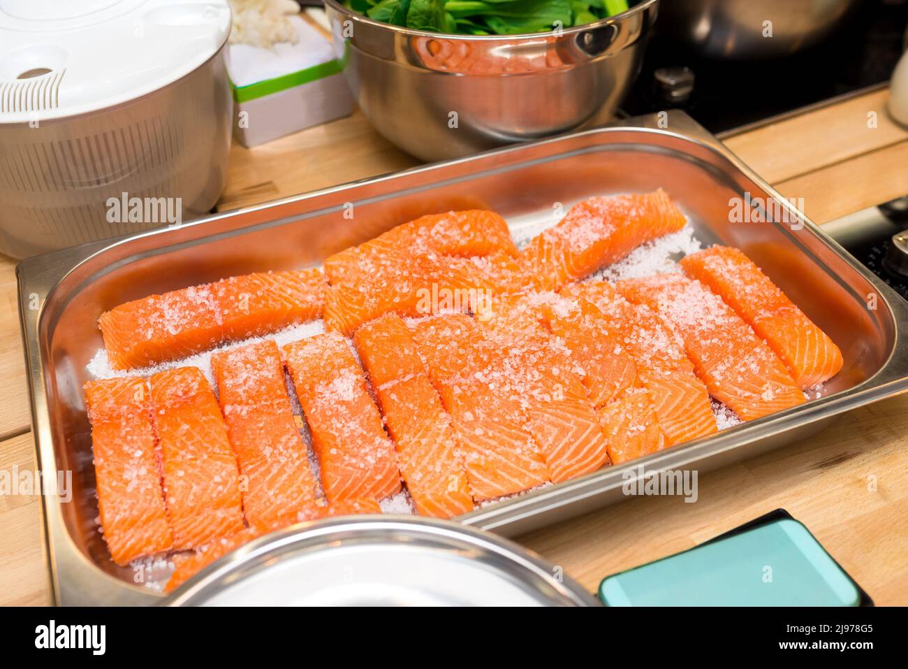 Plateau métallique avec filets de saumon crus sous gros sel. Salées avant la cuisson. Banque D'Images