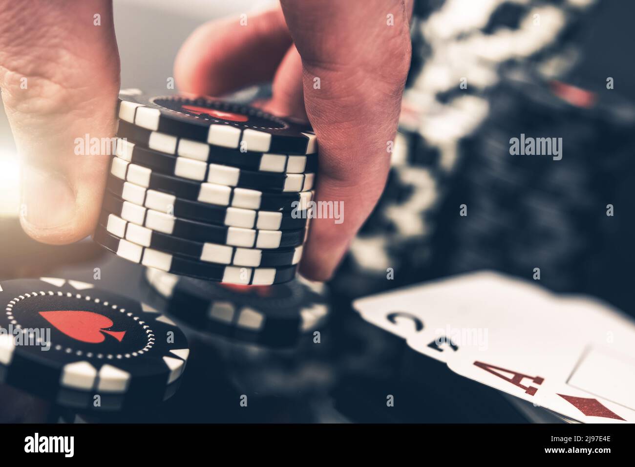Partie de poker à Paris. Gros plan d'un joueur plaçant une autre offre avec huit jetons de Casino. Banque D'Images