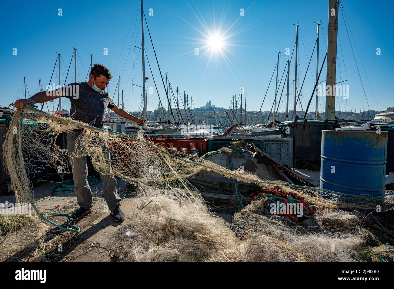 France. Marseille. Bouche-du-Rhône (13). Un pêcheur répare des filets dans le vieux port de Marseille Banque D'Images