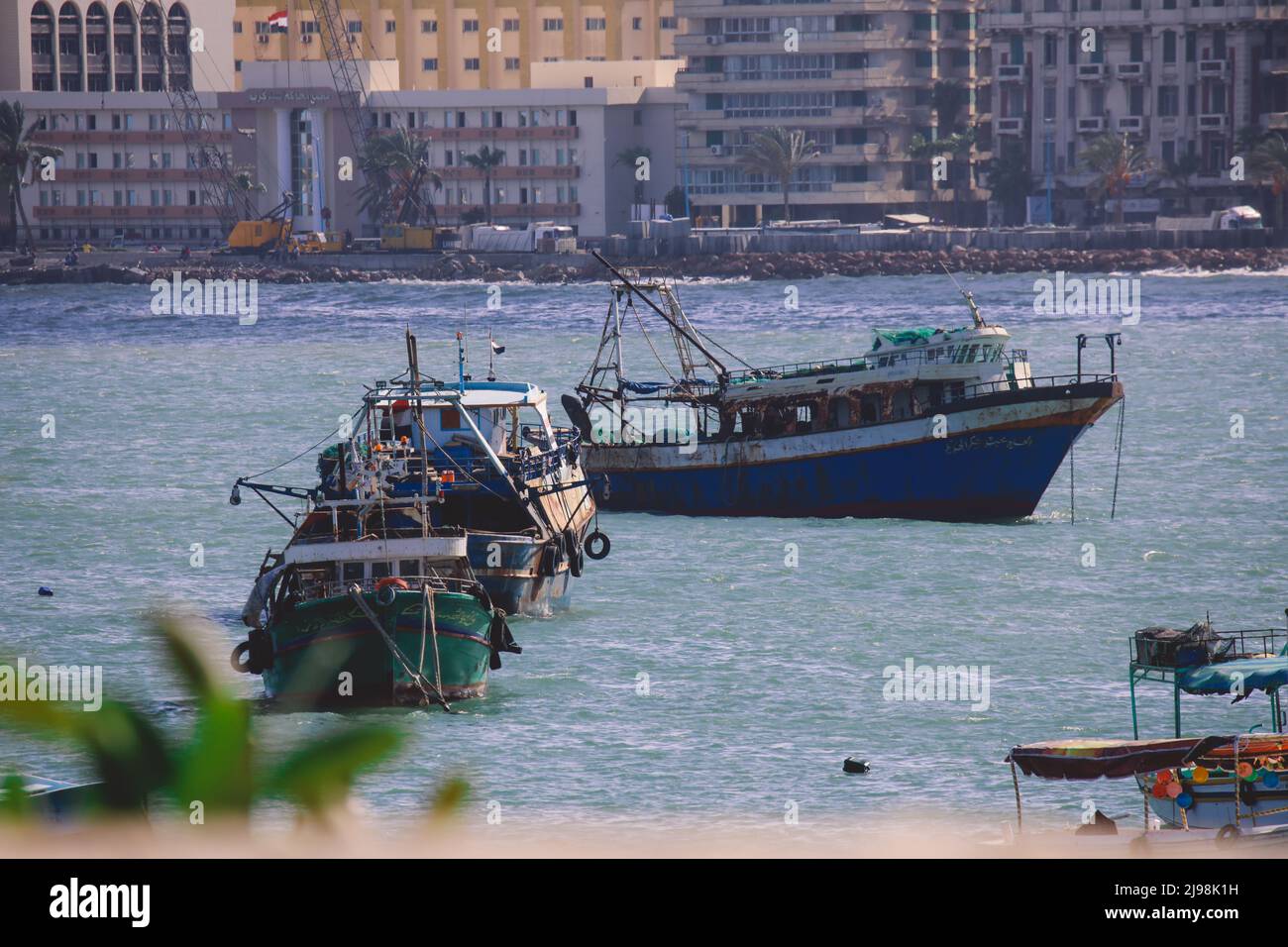 Vieux bateaux rouillés dans l'eau bleue du port d'Alexandrie, Egypte Banque D'Images