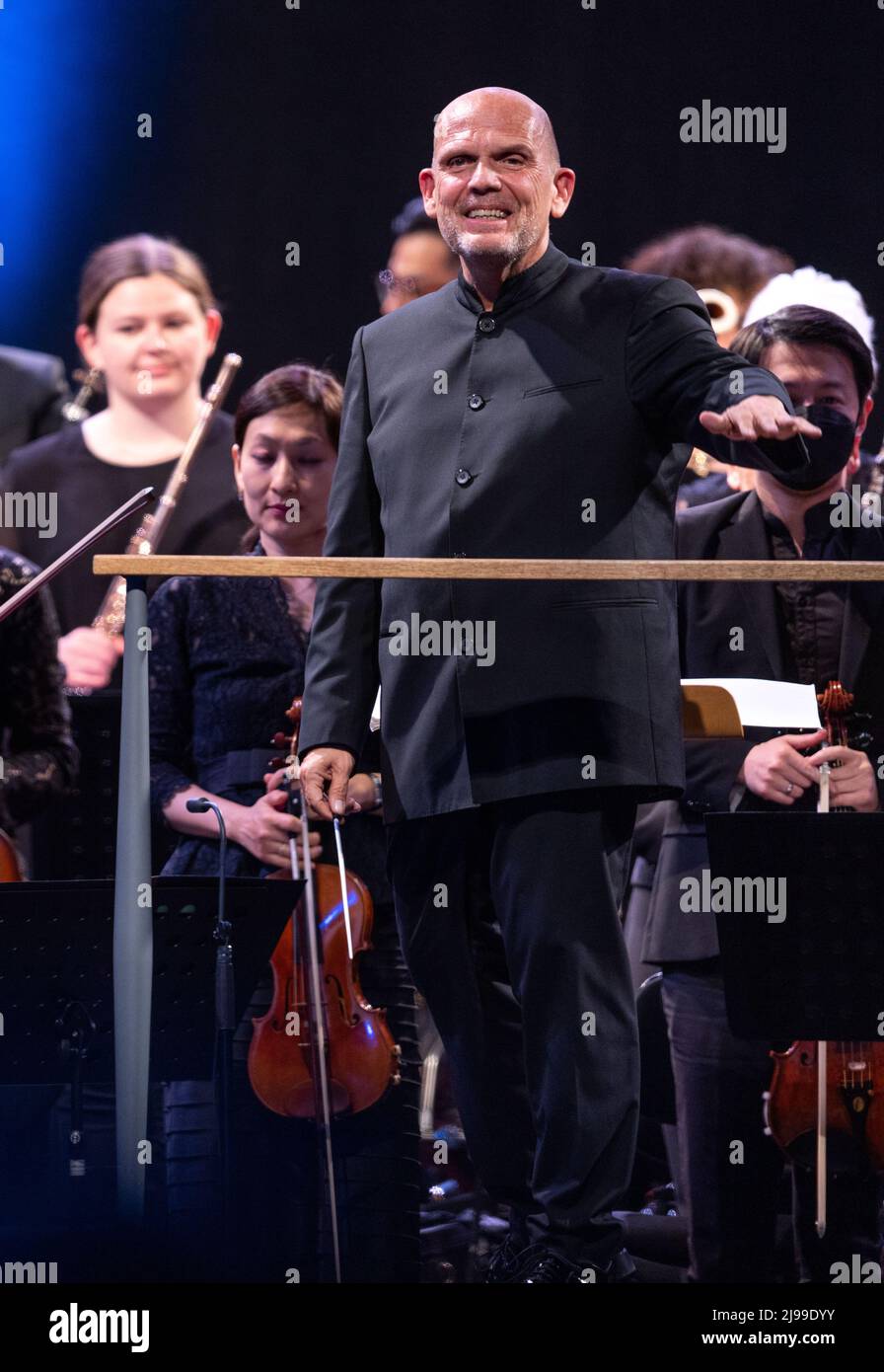 21 mai 2022, Mecklembourg-Poméranie occidentale, Peenemünde: Le chef d'orchestre Jaap van Zweden de l'Orchestre Philharmonique de New York remercie le public pour ses applaudissements au deuxième concert de l'ancienne centrale de Peenemünde sur l'île d'Usedom en mer Baltique. La résidence de cinq jours vise à envoyer un signal pour la liberté, la paix et la diversité, a déclaré l'organisateur. Les concerts sur la côte Baltique sont la première apparition d'invités étrangers de l'Orchestre philharmonique de New York depuis la pandémie de Corona. Photo: Jens Büttner/dpa Banque D'Images