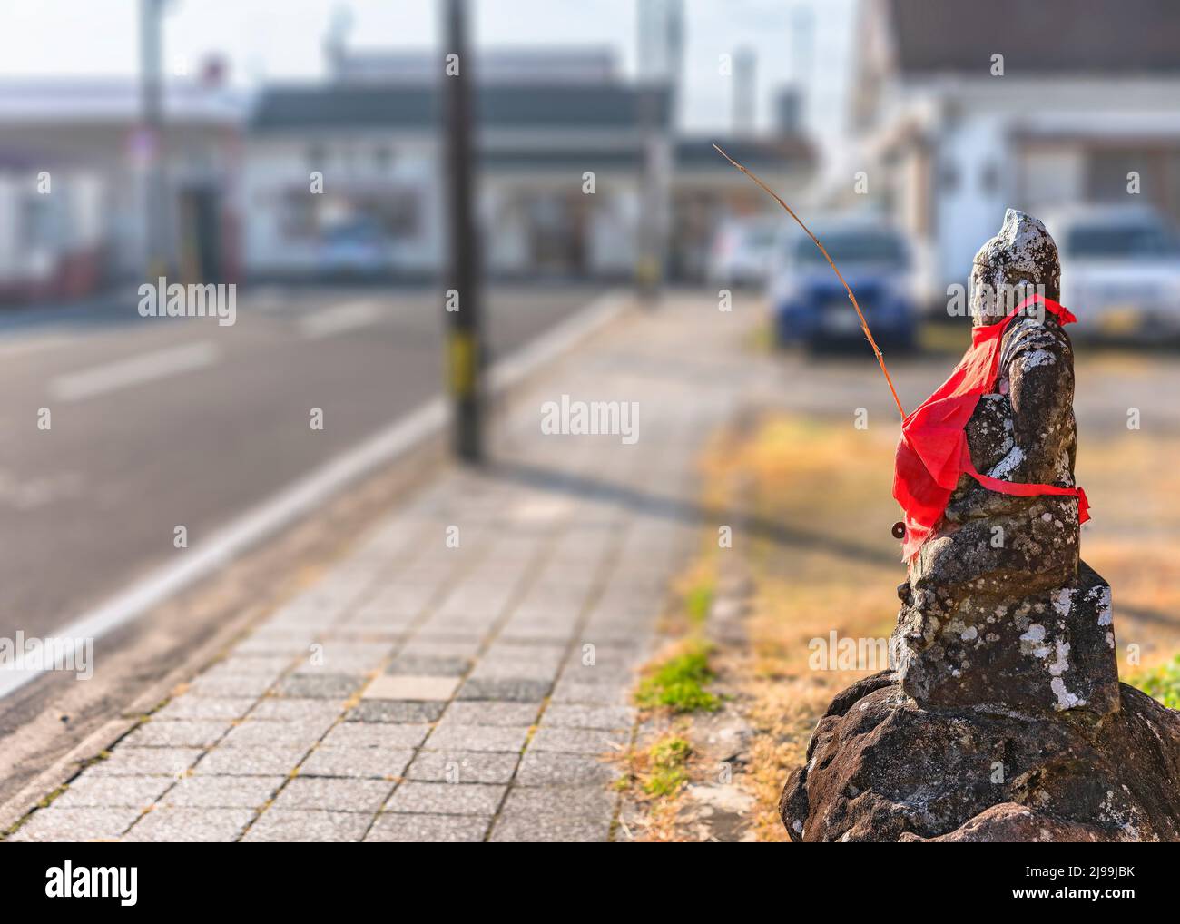 nagasaki, kyushu - décembre 10 2021 : statue en pierre de la divinité du Shinto Ebisu qui est le dieu des pêcheurs qui porte une canne à pêche et porte un bébé rouge Banque D'Images