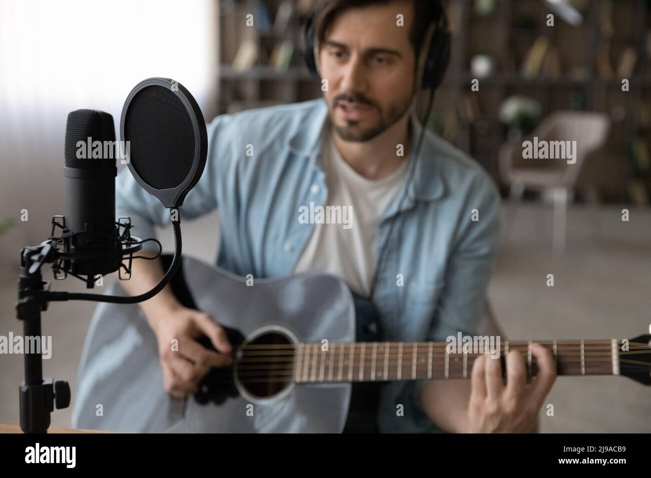 Guitariste professionnel joue de la guitare dans un studio domestique en utilisant un équipement spécial Banque D'Images