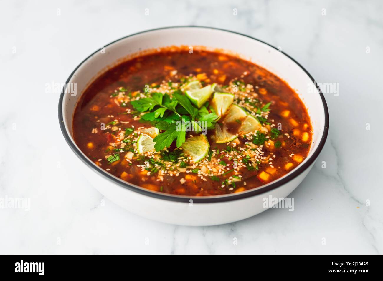 soupe végétalienne d'inspiration mexicaine avec grains de maïs rouge et coriandre dans une soupe épicée aux tomates, recettes alimentaires saines à base de plantes Banque D'Images