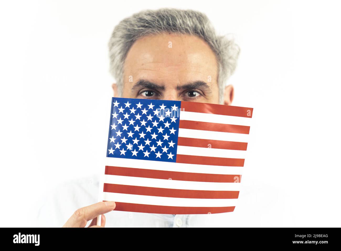 40s homme caucasien cachant le drapeau américain - portrait isolé sur fond blanc.Photo de haute qualité Banque D'Images
