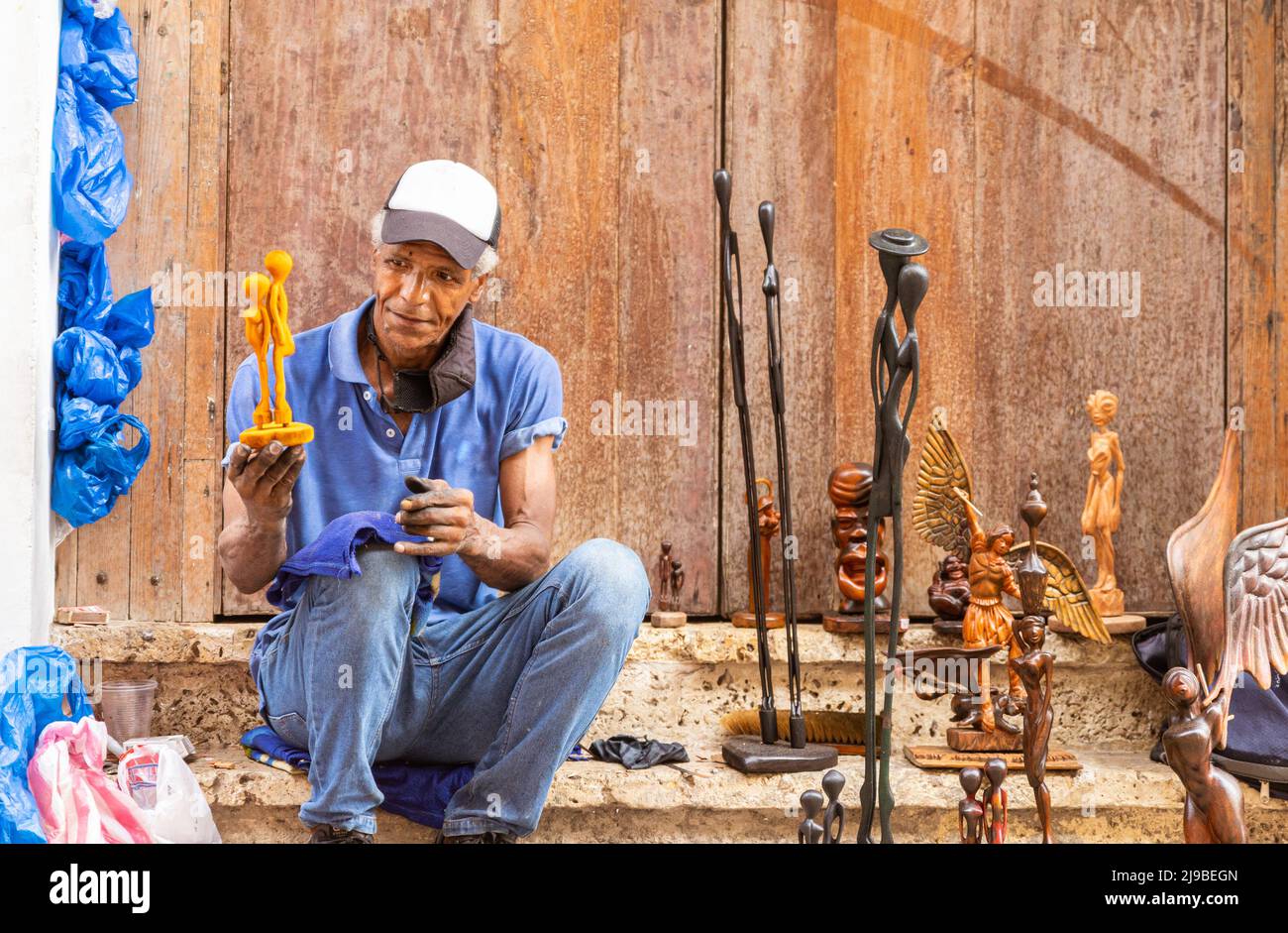 ancien artiste de rue afro-américain montrant sa sculpture en bois Banque D'Images