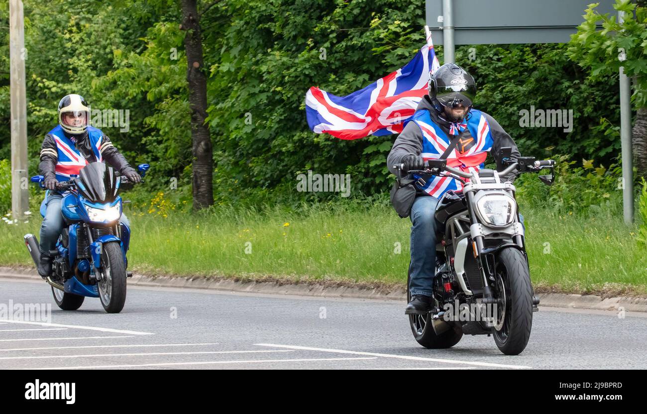 Milton Keynes, Royaume-Uni, 22nd mai 2022. Les cavaliers du Distinguished Gentleman’s Ride de Milton Keynes à Bedford vêtus de gilets Union Jack et portant un drapeau Union Jack Banque D'Images