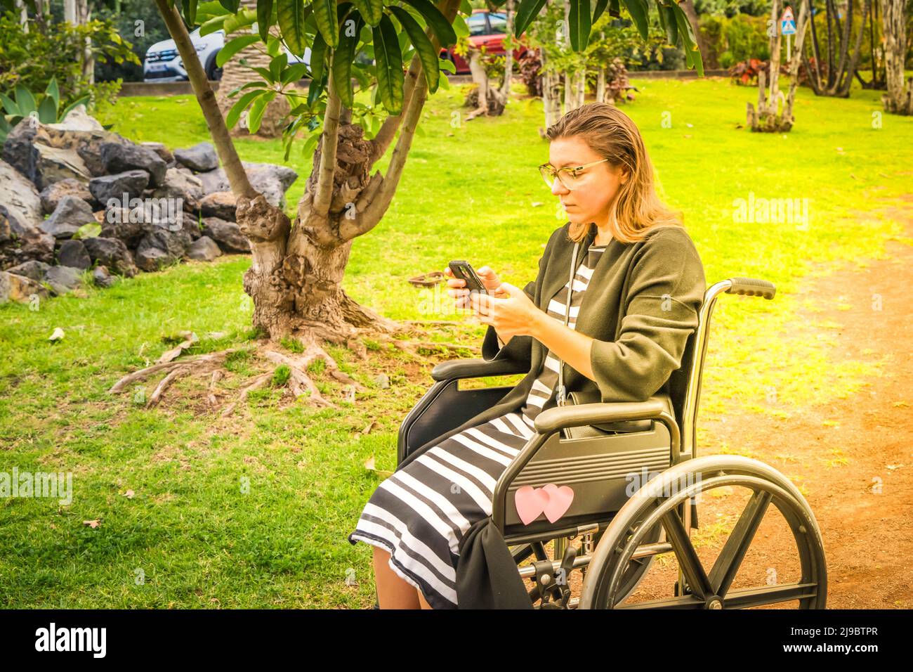 Femme handicapée en fauteuil roulant sur une colline de montagne avec vue Banque D'Images Femme handicapée en fauteuil roulant sur une colline de montagne avec vue Banque D'Images