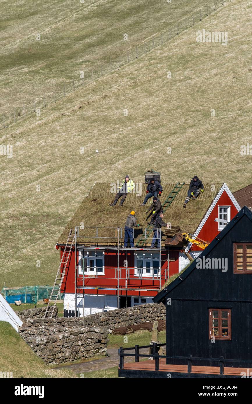 Les couvreurs prenant un repos sur le toit d'une maison dans les îles Féroé. Banque D'Images