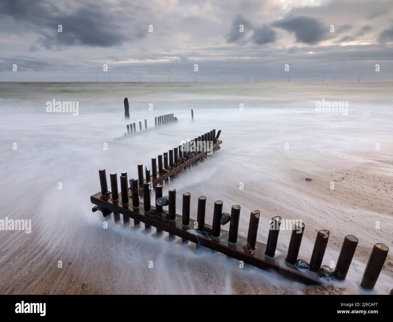 Vagues se lavant au-dessus d'une groyne en bois à Caister-on-Sea à Norfolk. Banque D'Images