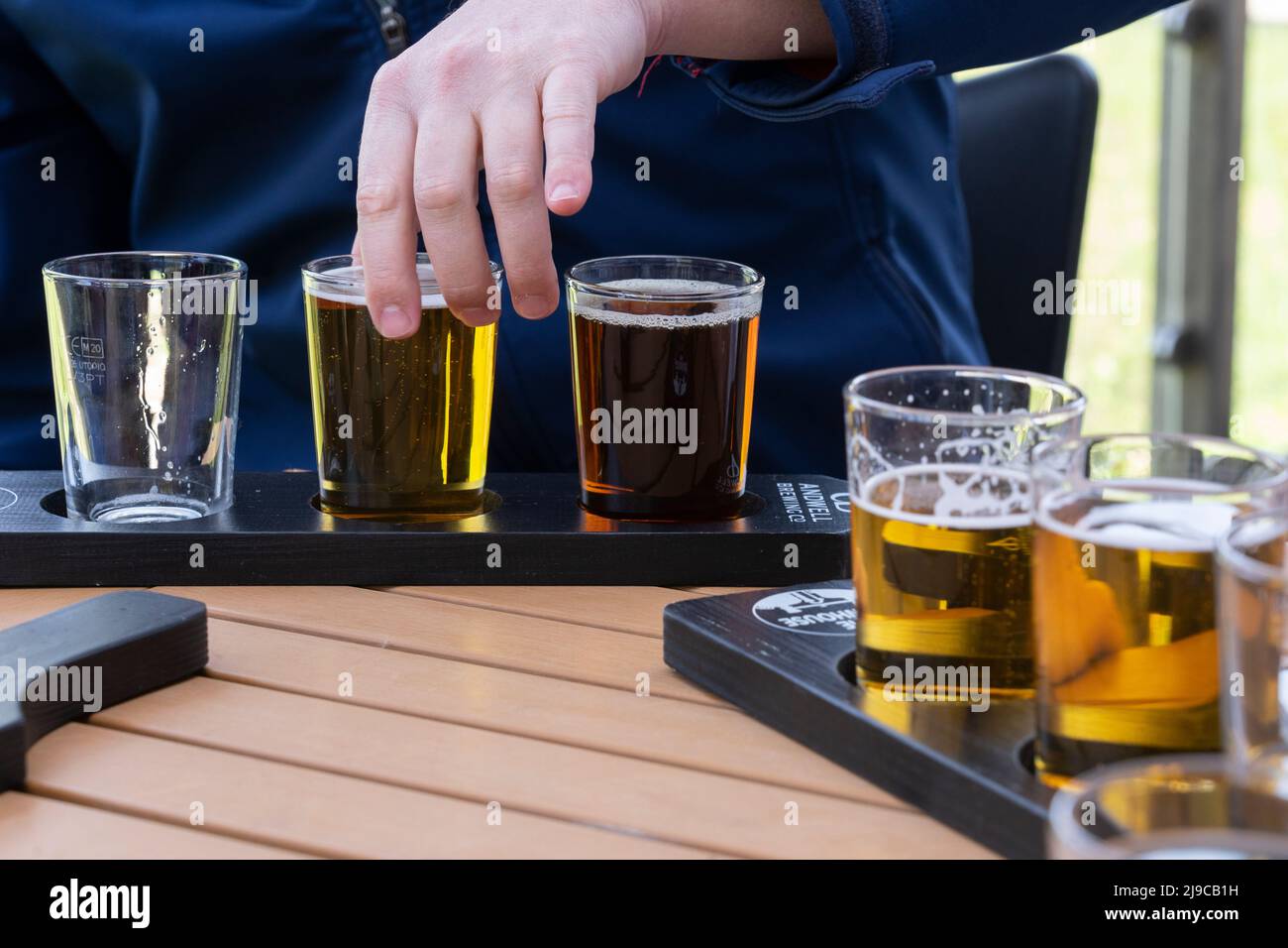 Amis qui profitent d'une expérience de dégustation de bière avec des verres de dégustation de demi-pinte de différentes bières à la brasserie Andwell, Hook, Hampshire, Angleterre Banque D'Images