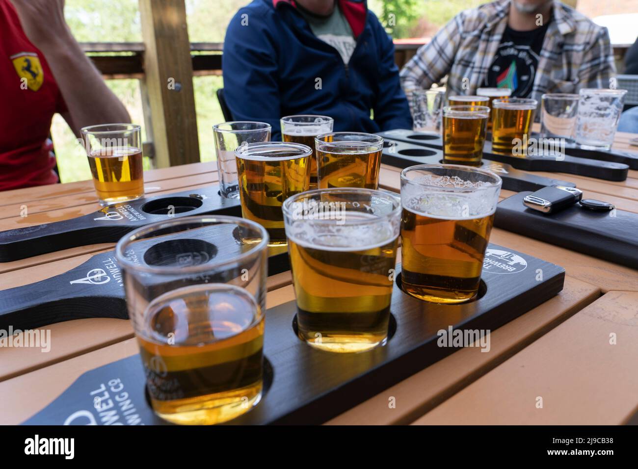 Amis qui profitent d'une expérience de dégustation de bière avec des verres de dégustation de demi-pinte de différentes bières à la brasserie Andwell, Hook, Hampshire, Angleterre Banque D'Images