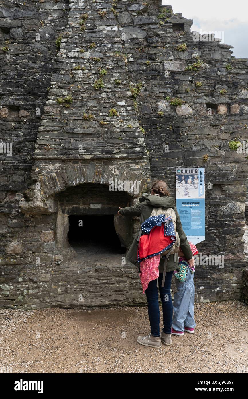 Une mère et une fille visitant les ruines du château de Kidwelly et regardant le bakehouse et le four. Mai. Kidwelly, Carmarthen, pays de Galles, Royaume-Uni Banque D'Images