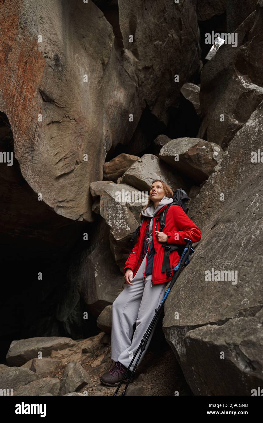 Adorable femme aventurier utilisant des bâtons de randonnée pendant la marche Banque D'Images