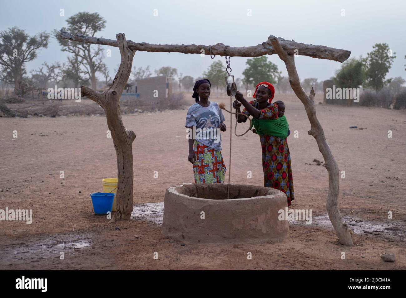 Ségou, Mali - Mars 13 2022 : Un village en Afrique. Les femmes africaines puisant de l'eau dans un puits d'eau local. Banque D'Images