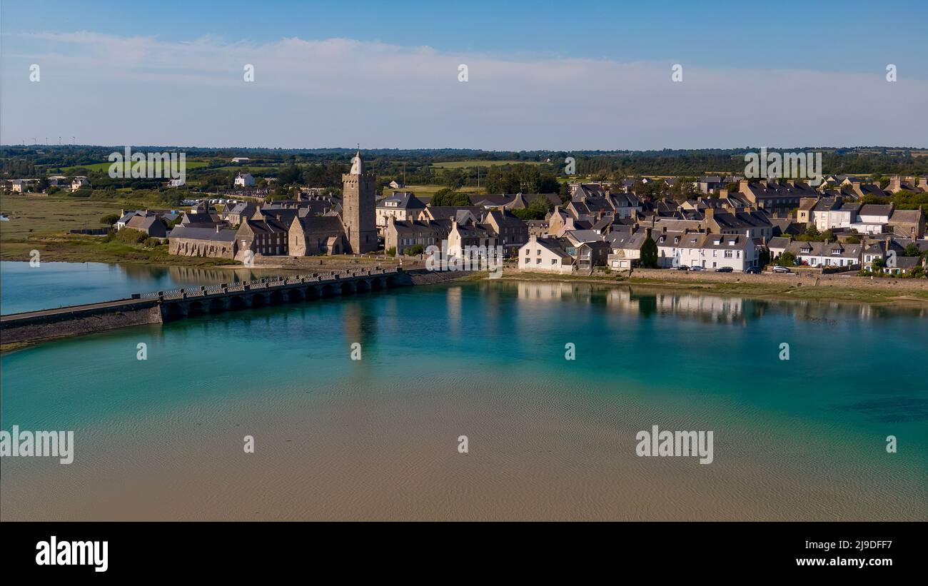 Vue sur l'église de Portbail depuis le pont avec un reflet de l'église dans l'eau Banque D'Images