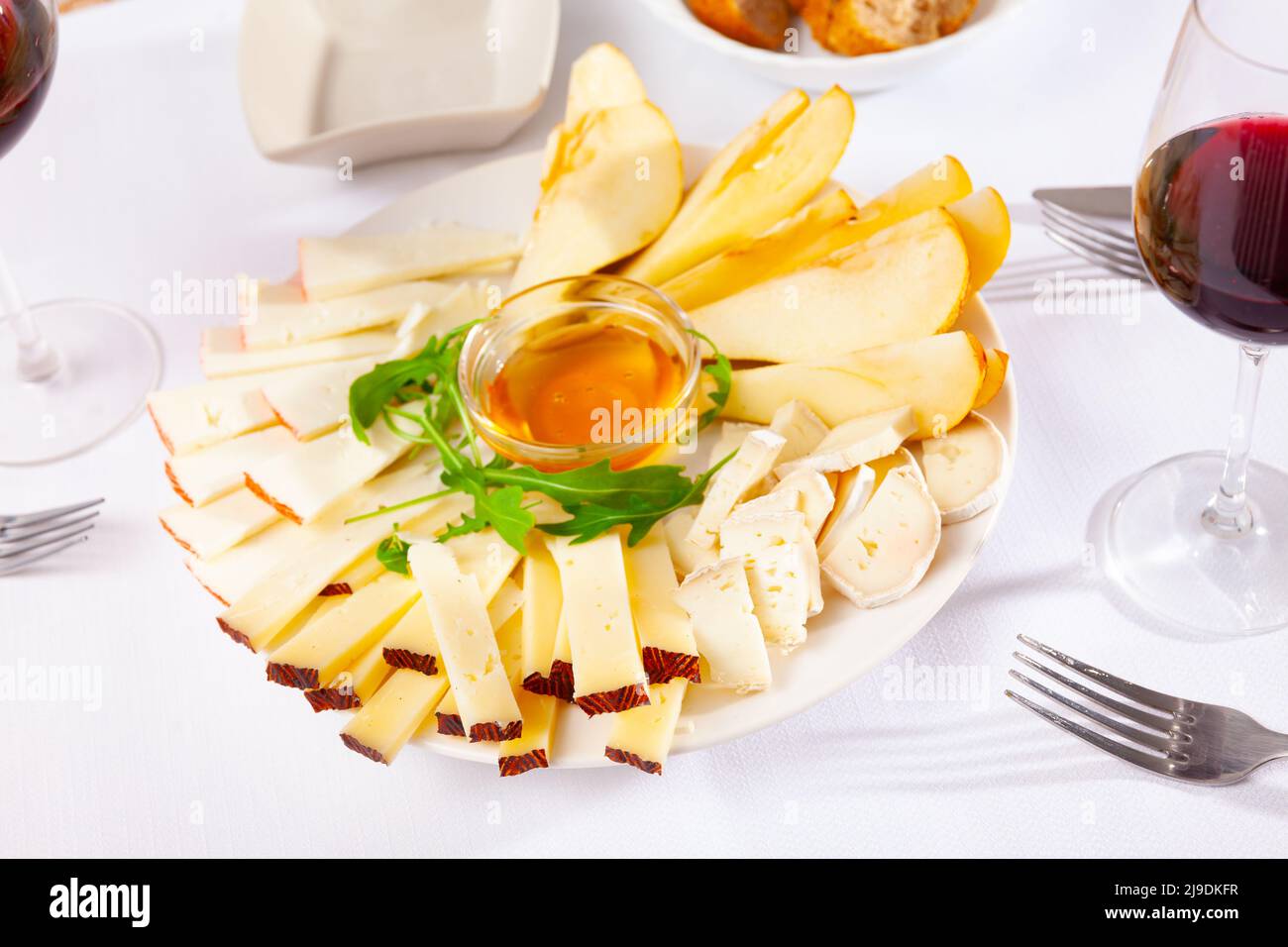 Différents types de fromage et de tranches de poire sur l'assiette Banque D'Images