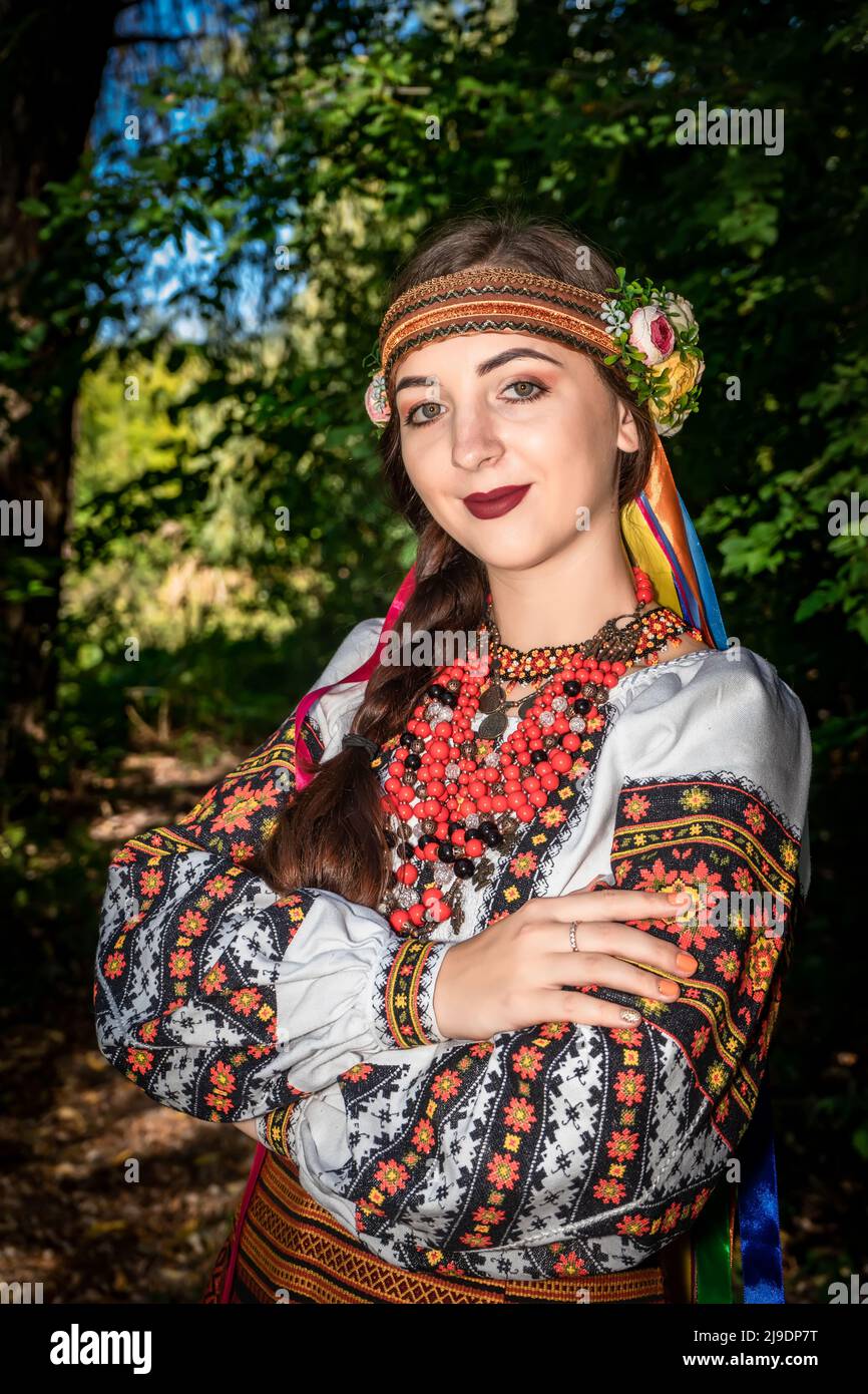 Fille ukrainienne dans la robe nationale ukrainienne se tient sur un chemin dans les bois Banque D'Images