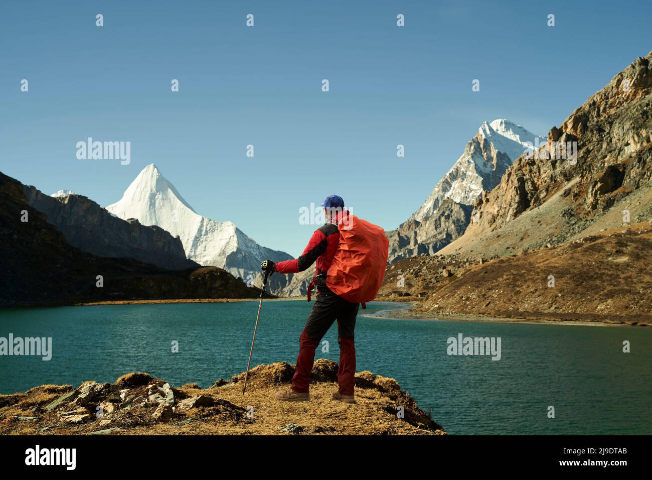 trekker asiatique debout près du lac boyongcuo regardant le mont jampayang (ou yangmaiyong) dans le parc national de yading, comté de daocheng, province du sichuan, chine Banque D'Images