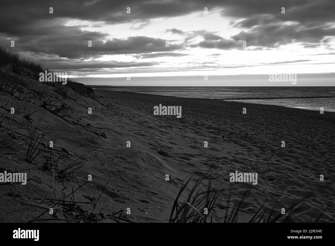 sur la plage de la mer baltique, en noir et blanc, avec nuages, dunes et plage. randonnée en automne. grand paysage pour des vacances Banque D'Images