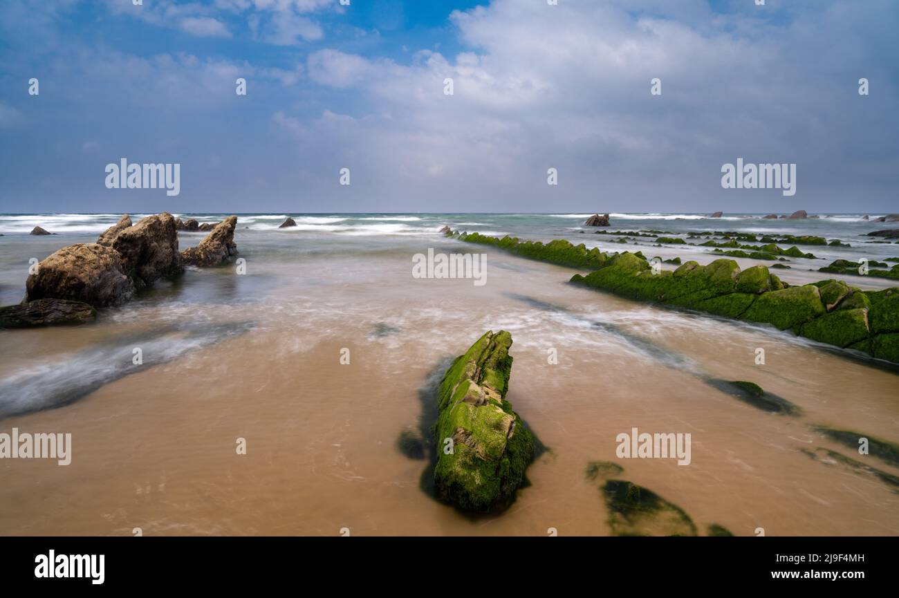 Une longue vue d'exposition des formations rocheuses de Flysch à marée basse à la plage de Barrika près de Bilbao Banque D'Images