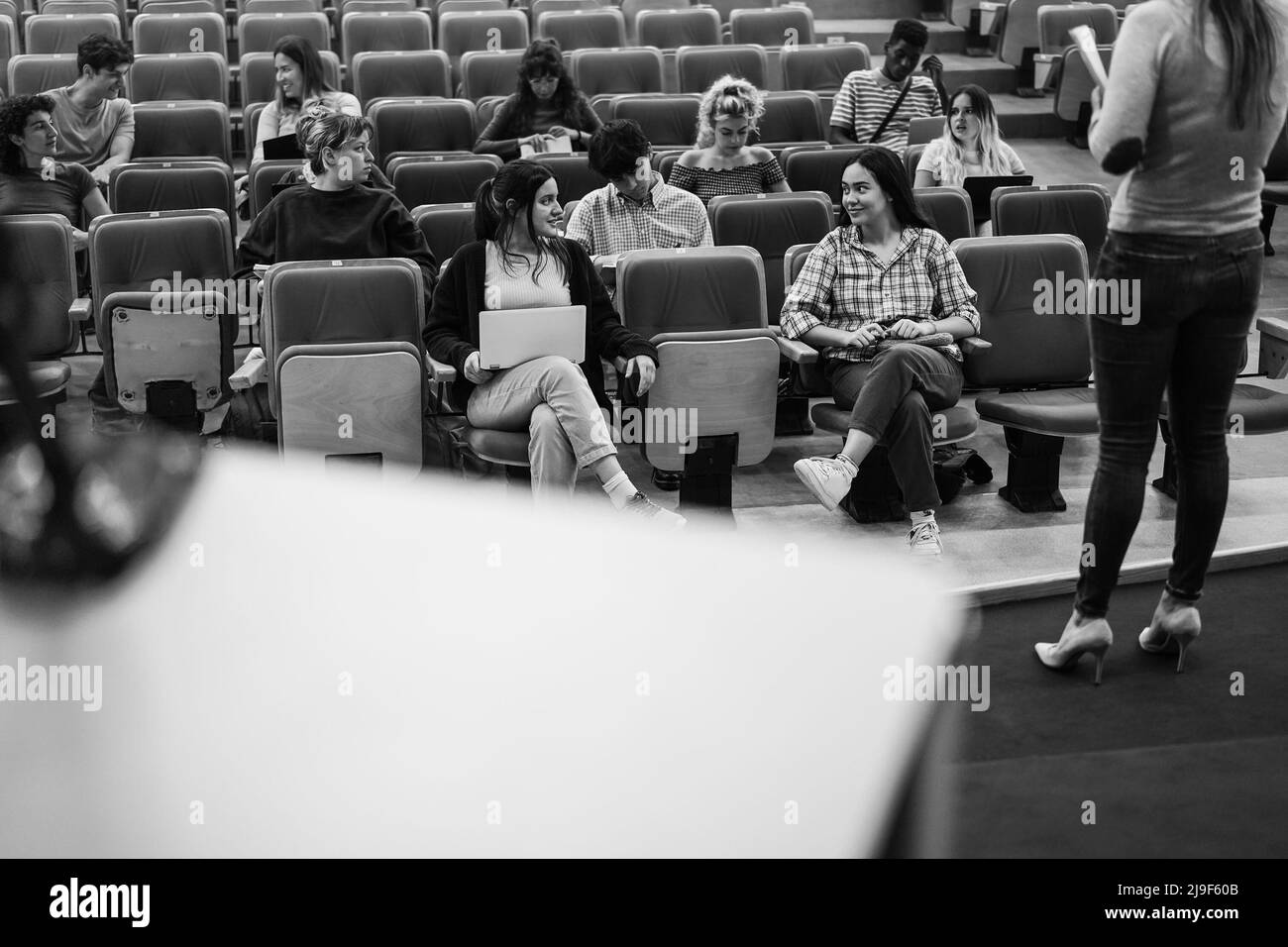 Jeunes étudiants à l'écoute du séminaire de conférence à l'intérieur de l'auditorium de l'université - Focus sur les visages de filles avant - montage noir et blanc Banque D'Images