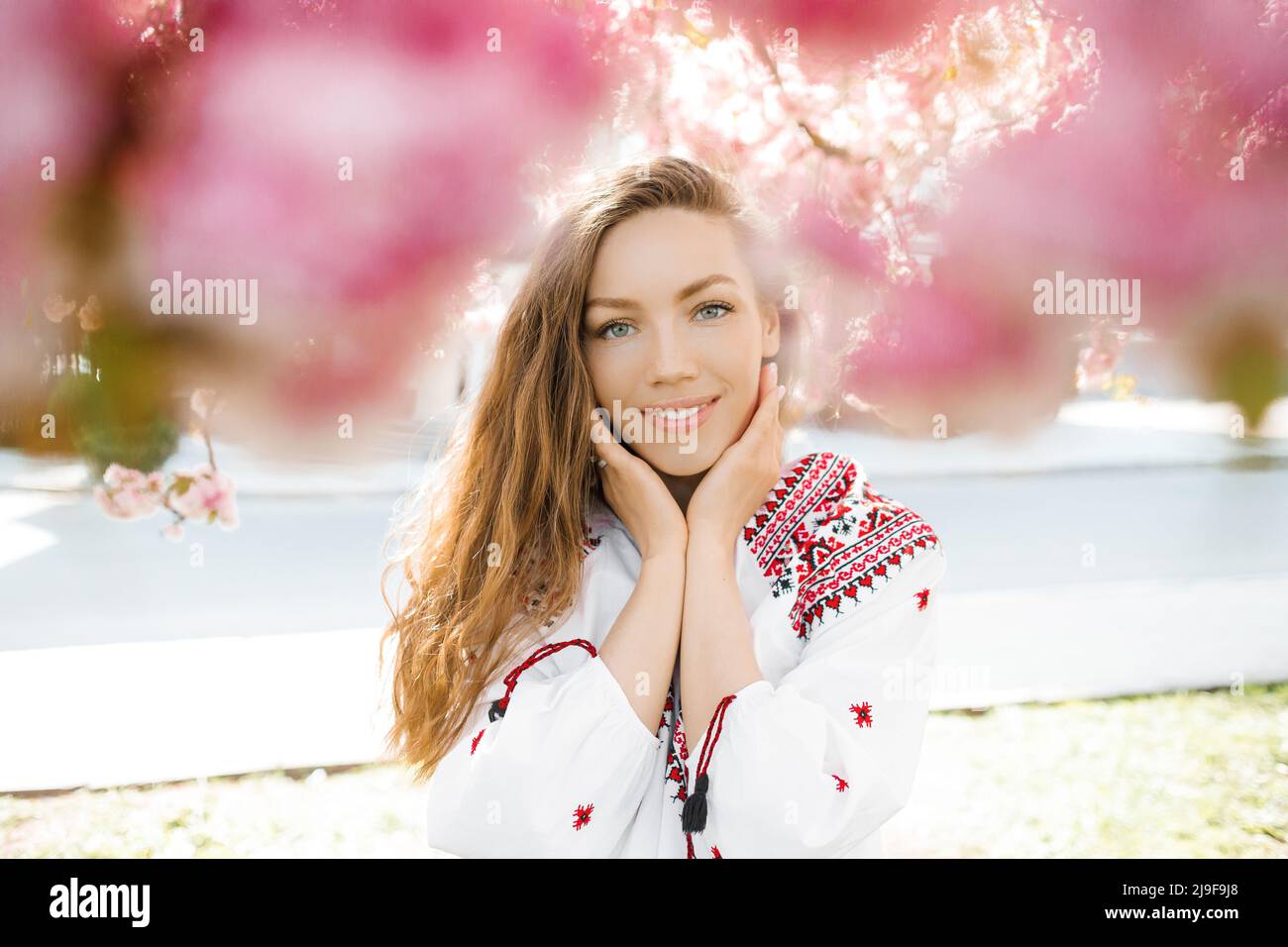 Portrait d'une femme mignonne dans le parc en fleurs de sakura. Concept de ressort. Banque D'Images