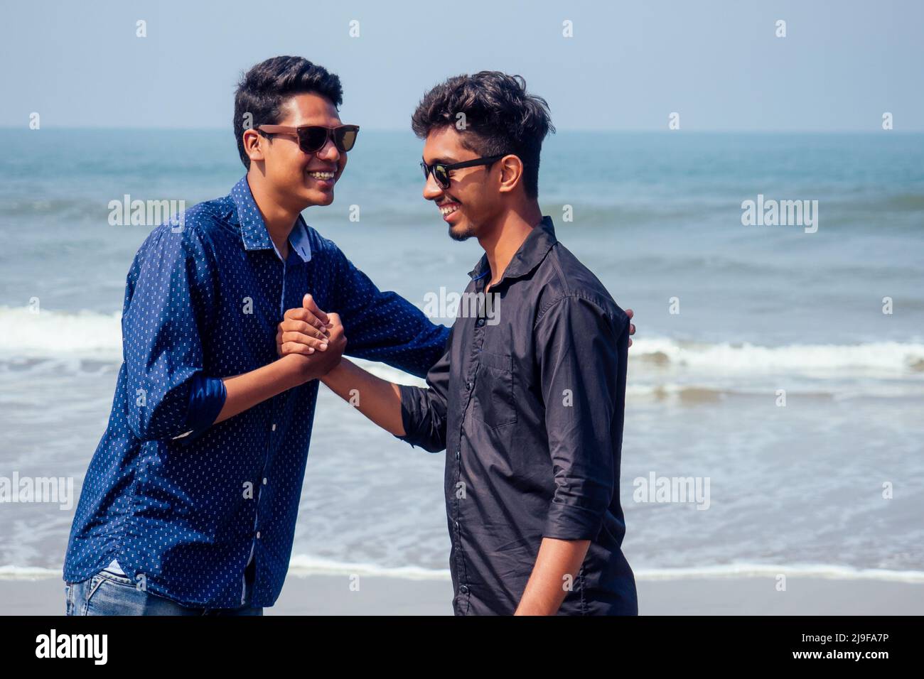 Hali heureux deux indiens élégants garçons jeunes amis embrassant sur la plage au bord de la mer.longtemps attendu réunion diwali des frères en Inde Goa tropical Banque D'Images
