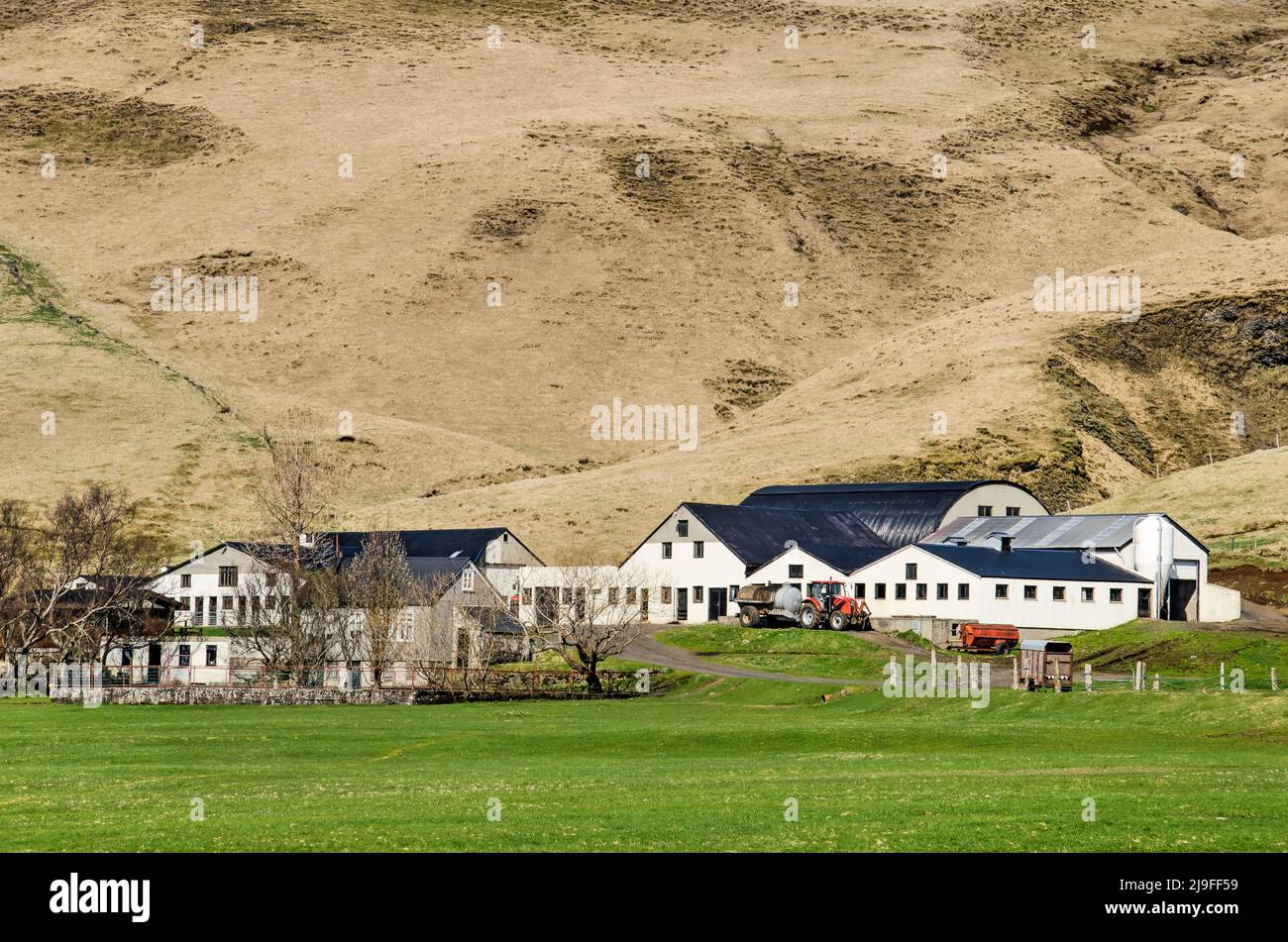 Skogar, Islande, 24 avril 2022: Grand complexe agricole avec des granges modernes et des équipements entre un pré vert et des pentes herbeuses Banque D'Images