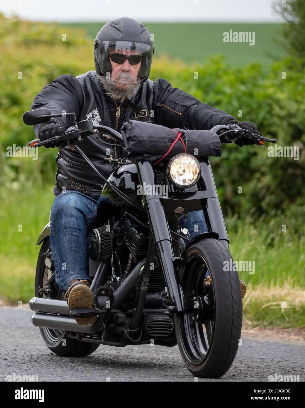 Homme barbu à cheval sur une moto Harley Davidson Banque D'Images