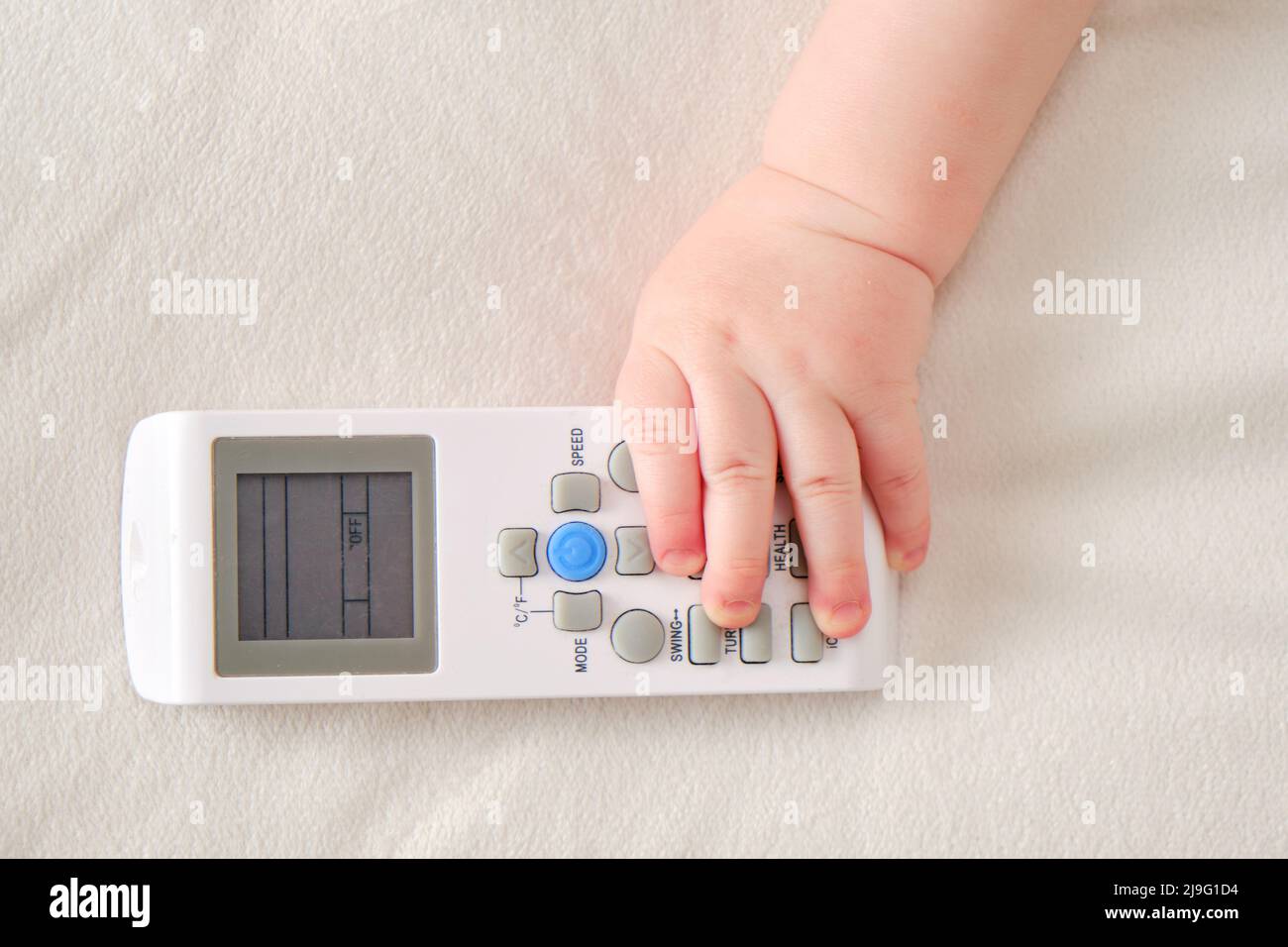 Bébé garçon tient la télécommande du climatiseur dans sa main. Enfant avec  télécommande pour la température, gros plan Photo Stock - Alamy