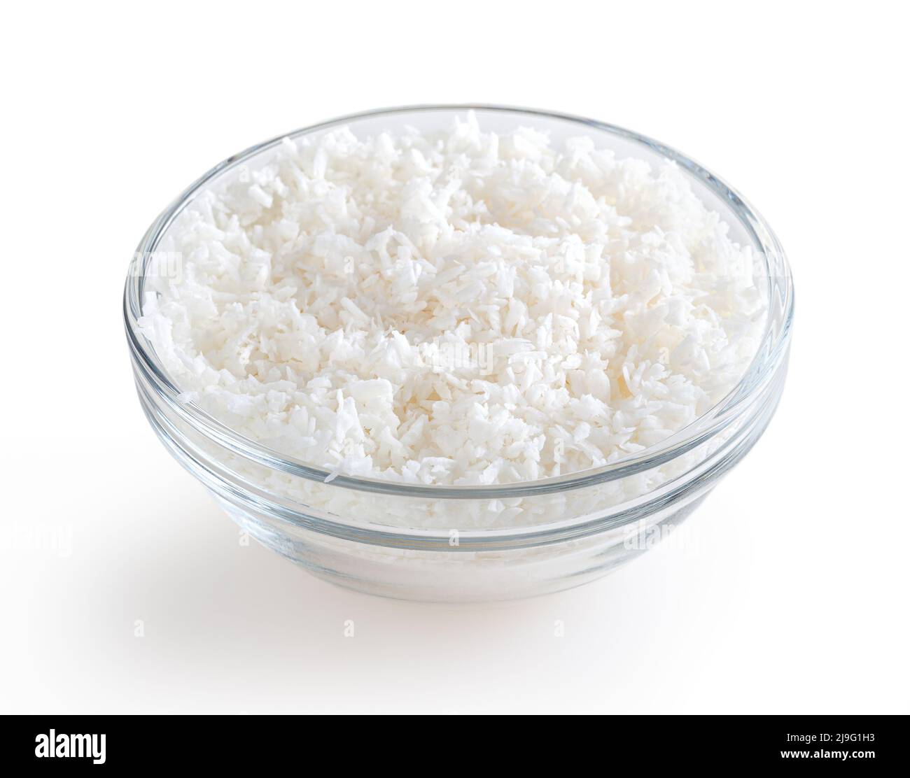 Flocons de noix de coco dans un bol en verre isolé sur fond blanc avec passe-cheveux Banque D'Images