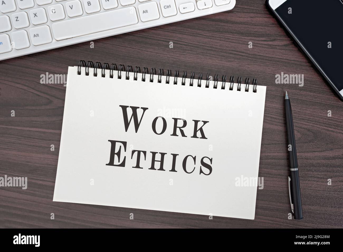 Vue de dessus et disposition plate du bureau et bloc-notes avec mot éthique de travail. Concept d'entreprise. Banque D'Images