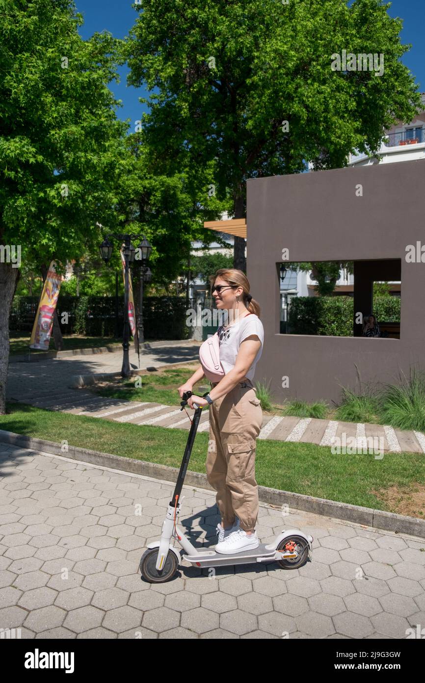 Jeune femme assise sur son scooter électrique Banque D'Images