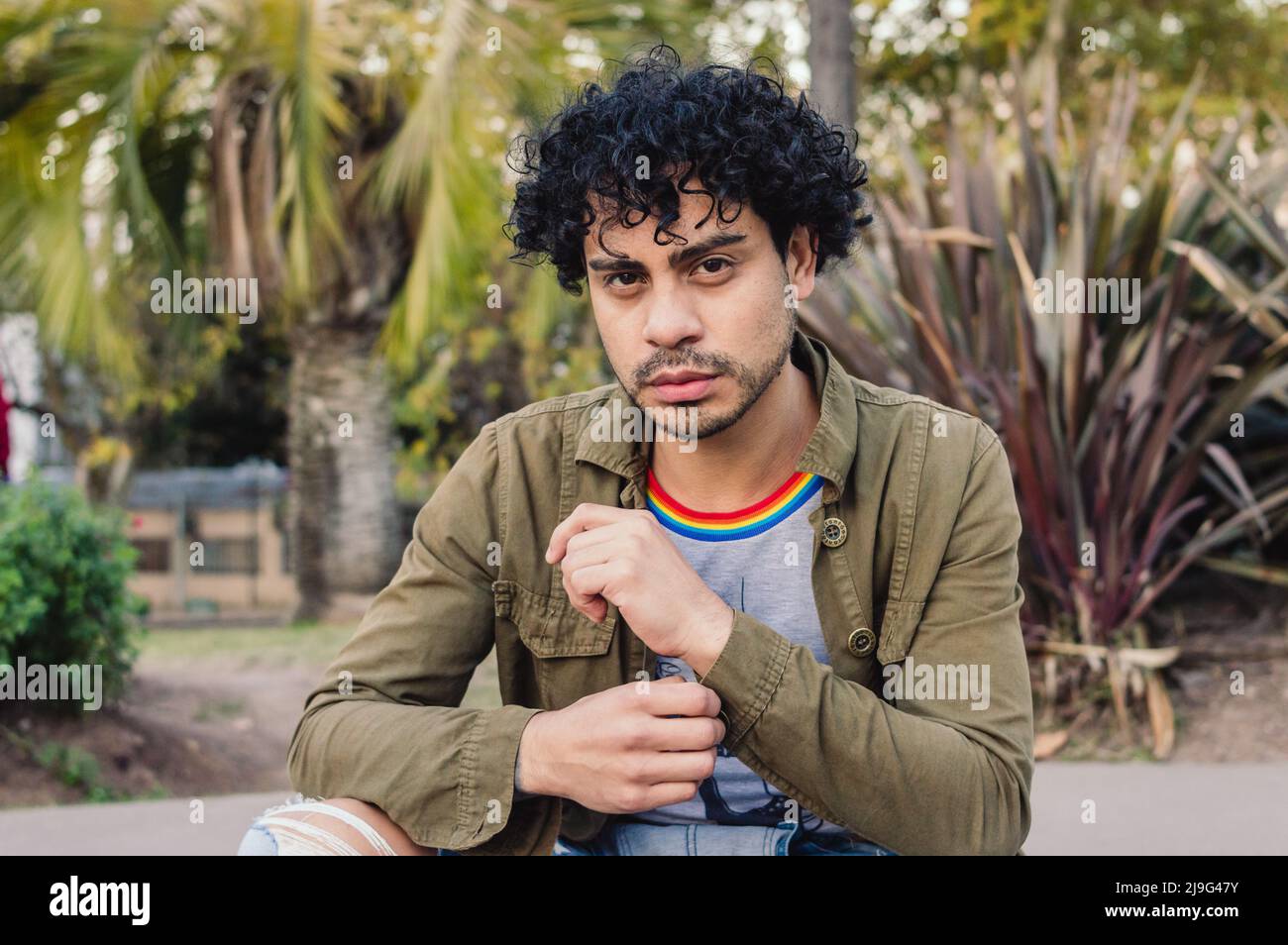 portrait d'un jeune homme du caucase du sud, avec des curlers, beau plein air regardant l'appareil photo. Banque D'Images