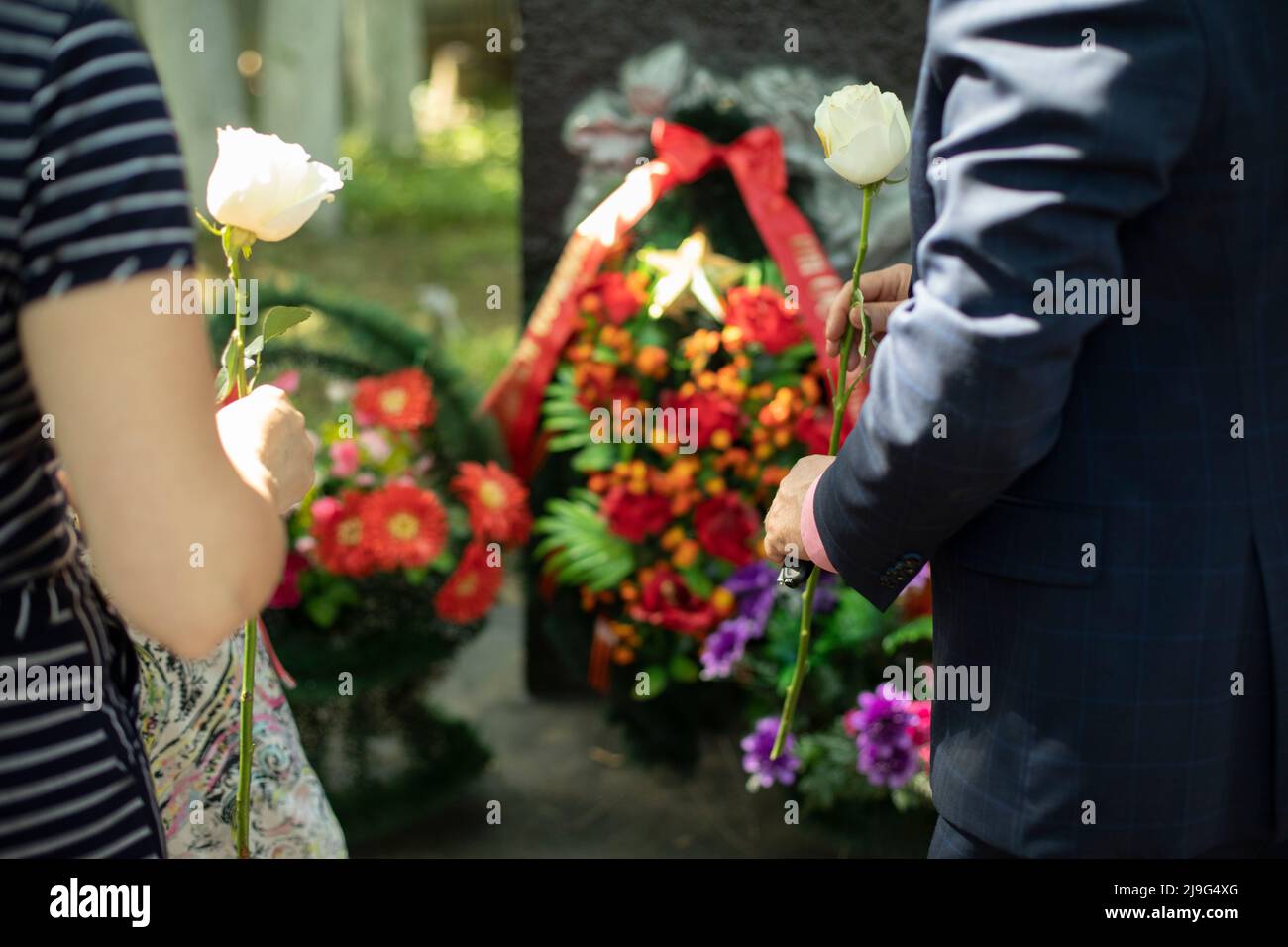 Fleurs sur le mémorial. Les gens posent des fleurs blanches sur le site de l'enterrement. Un événement mémorable. Le jour de la victoire en Russie. Un signe de respect pour la guerre déchue h Banque D'Images