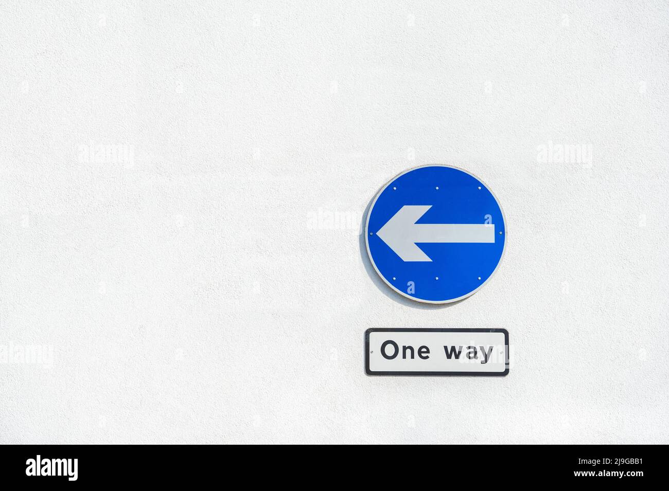 panneau de signalisation à sens unique sur un mur en béton blanc Banque D'Images