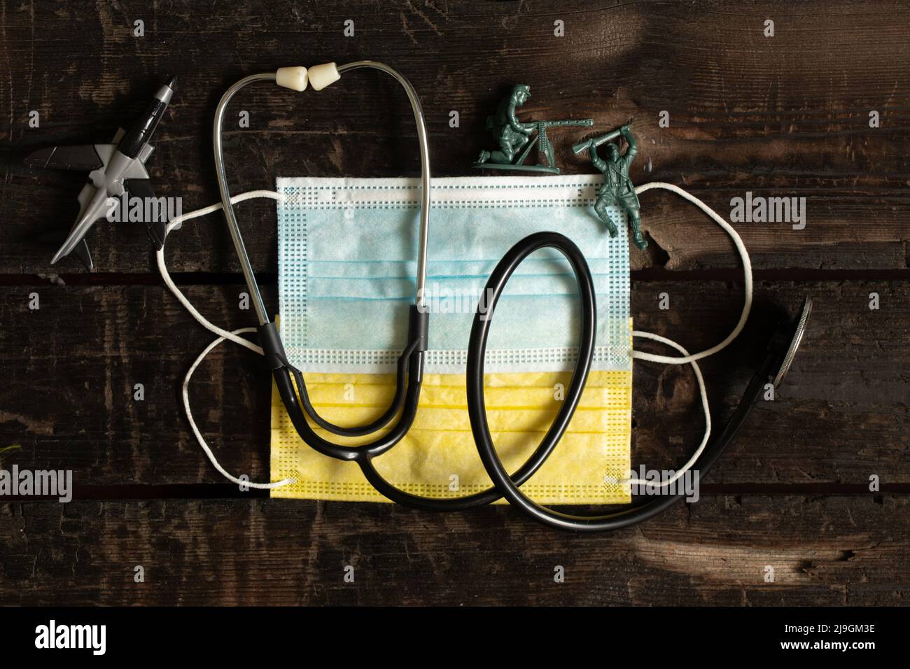 Des masques médicaux jaunes et bleus, comme le drapeau de l'Ukraine, un stéthoscope et des enfants soldats, se trouvent sur la table. Arrêter la guerre. La Russie est l'agresseur Banque D'Images