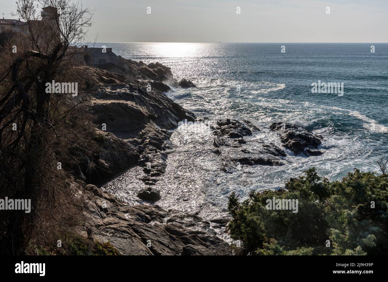 Vagues se brisant au-dessus de la côte rocheuse Mer Tyrrhénienne par la forteresse Rocca Spagnola à Porto Ercole sur le promontoire Monte Argentario, Toscane. Banque D'Images