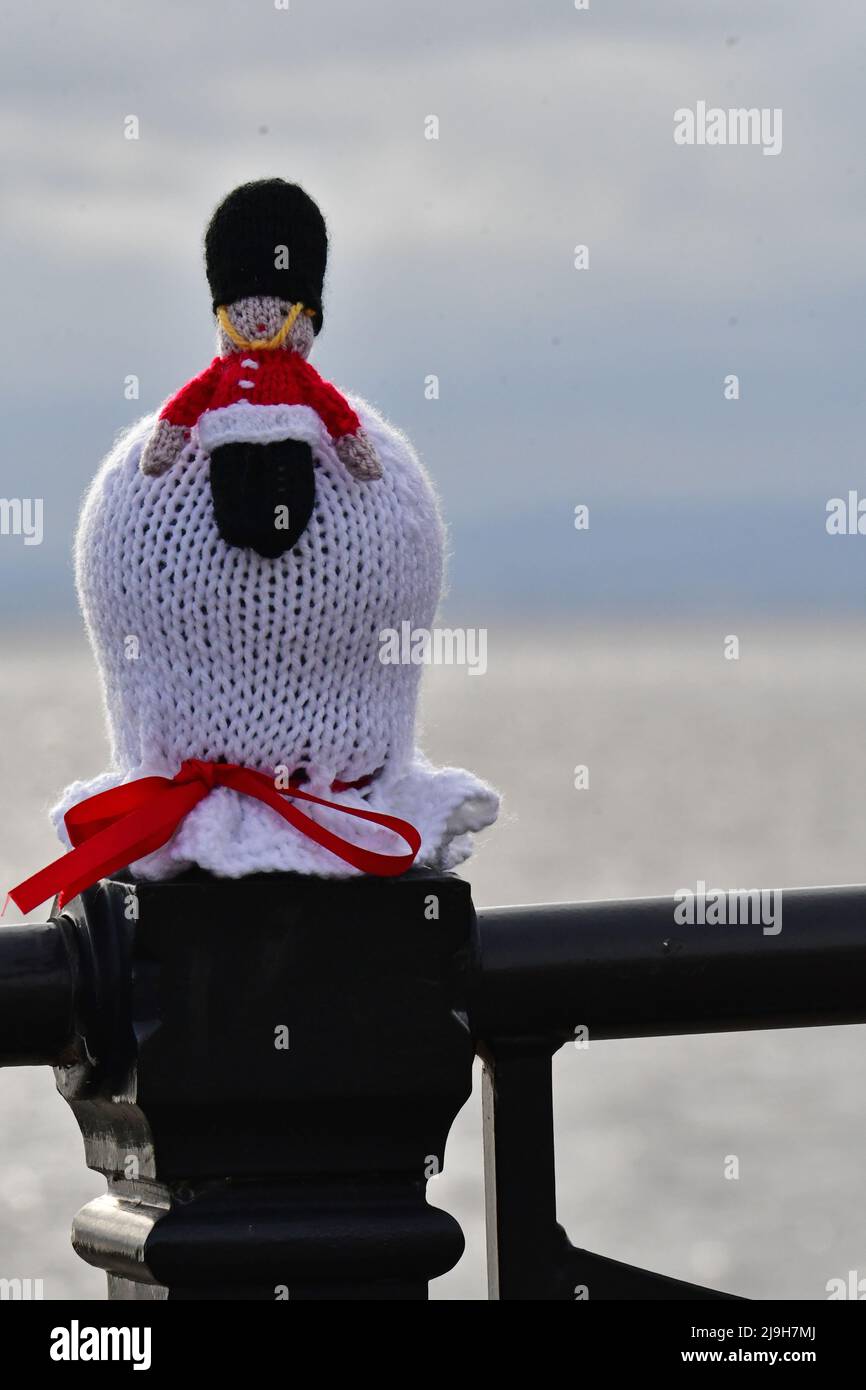 Clevedon, Royaume-Uni. 23rd mai 2022. Un lundi soir doux au front de mer de Clevedon, des chapeaux tricotés de toutes les couleurs sont vus assis au-dessus de la rambarde de de sécurité qui courent toute la longueur de la promenade se préparer pour le Jubilé de platine de la Reine. Crédit photo : Robert Timoney/Alay Live News Banque D'Images