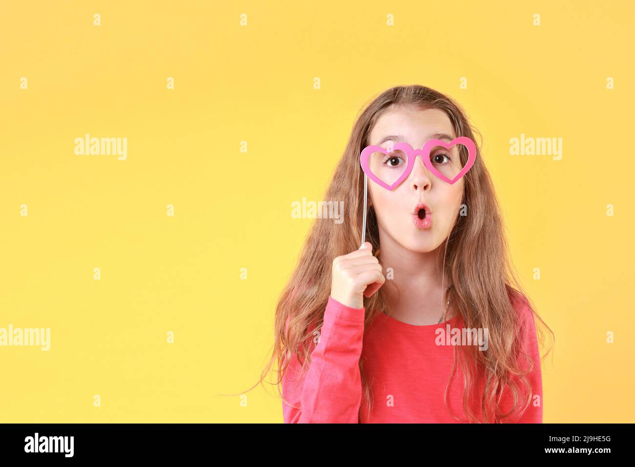 Caucasien enfant fille surprise visage sur yeloow espace vide fond.Publicité design, drôle visage enfant. Banque D'Images